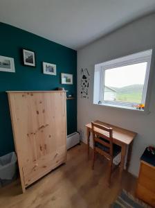 a room with a wooden desk and a window at Gunn Croft in Balallan