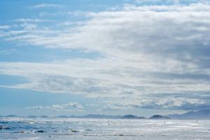 a person is flying a kite on the beach at Pousada Y-Goá in Bertioga