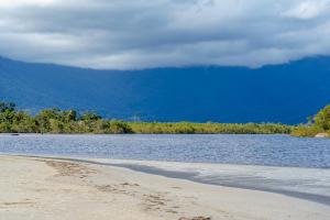 a body of water with trees and a mountain at Pousada Y-Goá in Bertioga