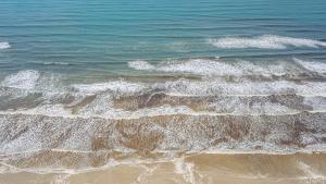 an overhead view of the ocean with waves at Pousada Y-Goá in Bertioga