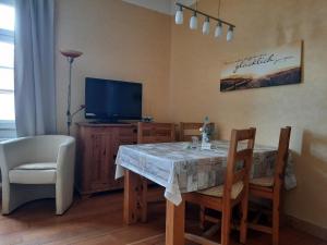 a dining room with a table and a television at Ferienwohnung zur alten Post in Lützen