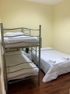 two bunk beds in a room with wooden floors at El cordal de laciana in Caboalles de Abajo