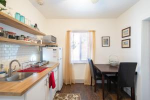 a kitchen with a table and a refrigerator and a table and chairs at Suite Life at Chez Mercedes in Miami