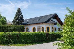 une maison blanche avec un toit noir dans l'établissement Ganzes Haus mit viel Platz für Familie und Freunde, à Klagenfurt am Wörthersee