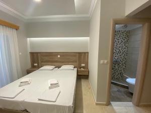 a bedroom with a bed and a bathroom with a tub at Hotel Filoxenia in Nei Poroi +70 photos