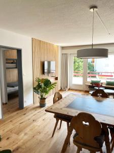 uma sala de estar com uma mesa de madeira e cadeiras em Haus Allod 208 em Lenzerheide
