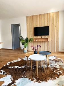 a living room with two tables and a tv at Haus Allod 208 in Lenzerheide