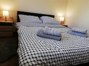 a bed with two blue pillows on top of it at Apartament Shadow in Białystok
