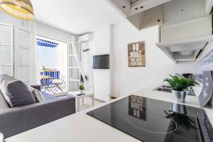 a kitchen and living room with a couch and a table at Sur Suites Castillo in Fuengirola