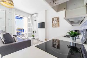 a kitchen and living room with a couch and a table at Sur Suites Astigi Vista Mar in Fuengirola