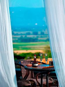 a table with two glasses and a bottle of wine at Orfeas Land in Kormísta +26 photos