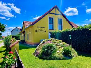 a yellow house with a sign that reads reunion schools at Penzion Sarton in Lukov