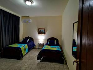 1 dormitorio con 2 camas en una habitación en Departamento vintage en Papantla de Olarte