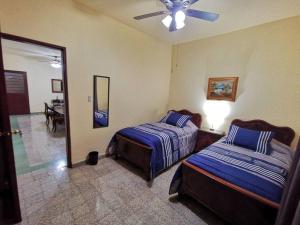 a bedroom with two beds and a ceiling fan at Departamento vintage in Papantla de Olarte