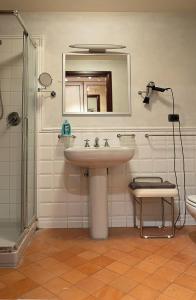 bagno con lavandino, doccia e specchio di Appartamento incantevole parcheggio nel residence a Medolla