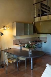 una cucina con tavolo, sedie e lavandino di Appartamento incantevole parcheggio nel residence a Medolla