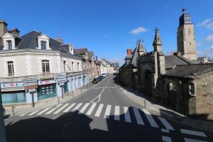 une rue vide dans une vieille ville avec des bâtiments dans l'établissement Appartement INDU Centre ville de VITRÉ, à Vitré