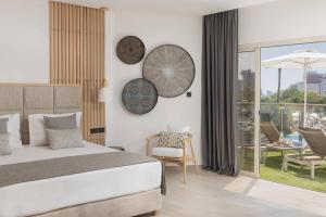 a hotel room with a bed and a balcony at Atlantica Bay - Adults Only in Limassol