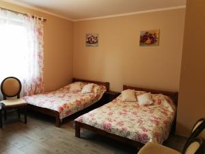 2 łóżka w małym pokoju z oknem w obiekcie Pensjonat Rosochate Wzgórze w mieście Rosochaty Róg