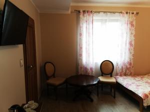 um quarto com uma mesa, uma cama e uma janela em Pensjonat Rosochate Wzgórze em Rosochaty Róg