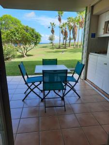 a table and chairs on a patio with a view of the ocean at studio village vacance sainte luce C5 in Sainte-Luce