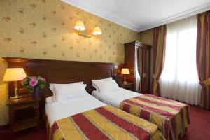 a hotel room with two beds and flowers on the wall at Elysees Niel Hotel in Paris