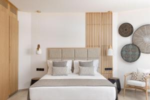 a bedroom with a large bed and a chair at Atlantica Bay - Adults Only in Limassol