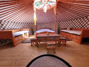 a room with two beds and a table in a yurt at Clos Des Monts in Saint-Martin-des-Besaces