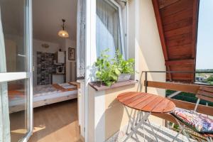 Habitación con balcón, cama y taburete. en Willa Arletta pokoje i strefa SPA, en Jastrzębia Góra