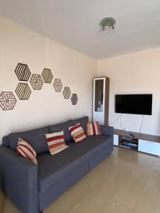 salon z niebieską kanapą i telewizorem z płaskim ekranem w obiekcie Apartamento Primera Linea de Playa w mieście Oropesa del Mar