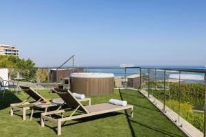 a patio with two chairs and a table on the grass at Atlantica Bay - Adults Only in Limassol
