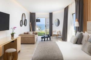 a hotel room with a bed and a living room at Atlantica Bay - Adults Only in Limassol