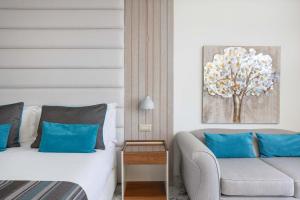 a hotel room with a bed and a couch at Atlantica Bay - Adults Only in Limassol