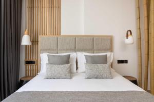 a bedroom with a large bed with white sheets and pillows at Atlantica Bay - Adults Only in Limassol