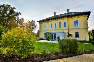 ein großes gelbes Haus mit einem Hof in der Unterkunft Villa Aurelie in Velké Losiny