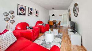 - un salon avec deux chaises rouges et une télévision dans l'établissement black-forest holiday - Ferienresort am Schluchsee, à Schluchsee