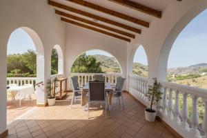 een balkon met bogen en een tafel en stoelen bij Villa Bárbara Piscina Vallada con Barbacoa Ideal Grupos By CostadelSolEscapes in Málaga