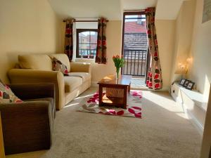 a living room with a couch and a table at The Old Bakery Seahouses in Seahouses