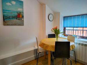 a dining room with a table and chairs and a clock at The Old Bakery Seahouses in Seahouses