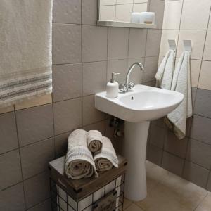 a bathroom with a white sink and towels at Amelie's Apartments in Mesolongion