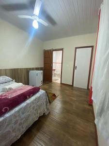 a bedroom with a bed and a ceiling fan at Sítio Maravilha em Domigos Martins in Domingos Martins