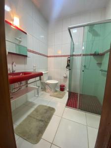 a bathroom with a shower and a sink and a toilet at Sítio Maravilha em Domigos Martins in Domingos Martins