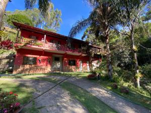 a red house with a driveway in front of it at Sítio Maravilha em Domigos Martins in Domingos Martins