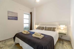 a bedroom with a large bed with two towels on it at Sur Suites Astigi Vista Mar in Fuengirola +30 photos