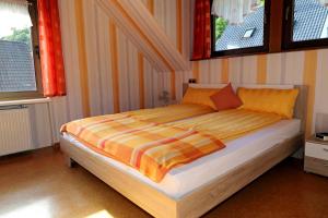 a large bed in a room with two windows at Lahn-er-leben in Geilnau