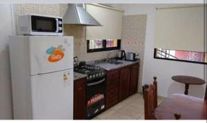 een keuken met een witte koelkast en een magnetron bij Cabañas el atardecer in San José