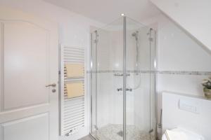 a bathroom with a shower with a glass door at Haus Claßen in Hörnum