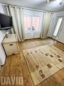 a living room with a flat screen tv and a large window at Casa David in Braşov