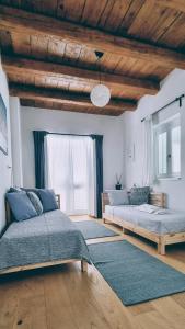 1 Schlafzimmer mit 2 Betten und Holzdecke in der Unterkunft Rector's Villa - Charming Retreat in Old Town with Jacuzzi in Private Courtyard in Rab