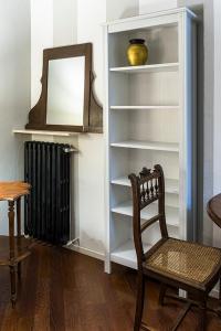 une chaise dans une pièce avec miroir et radiateur dans l'établissement Appartamento Interno DeGobbi, à Reggio d'Émilie